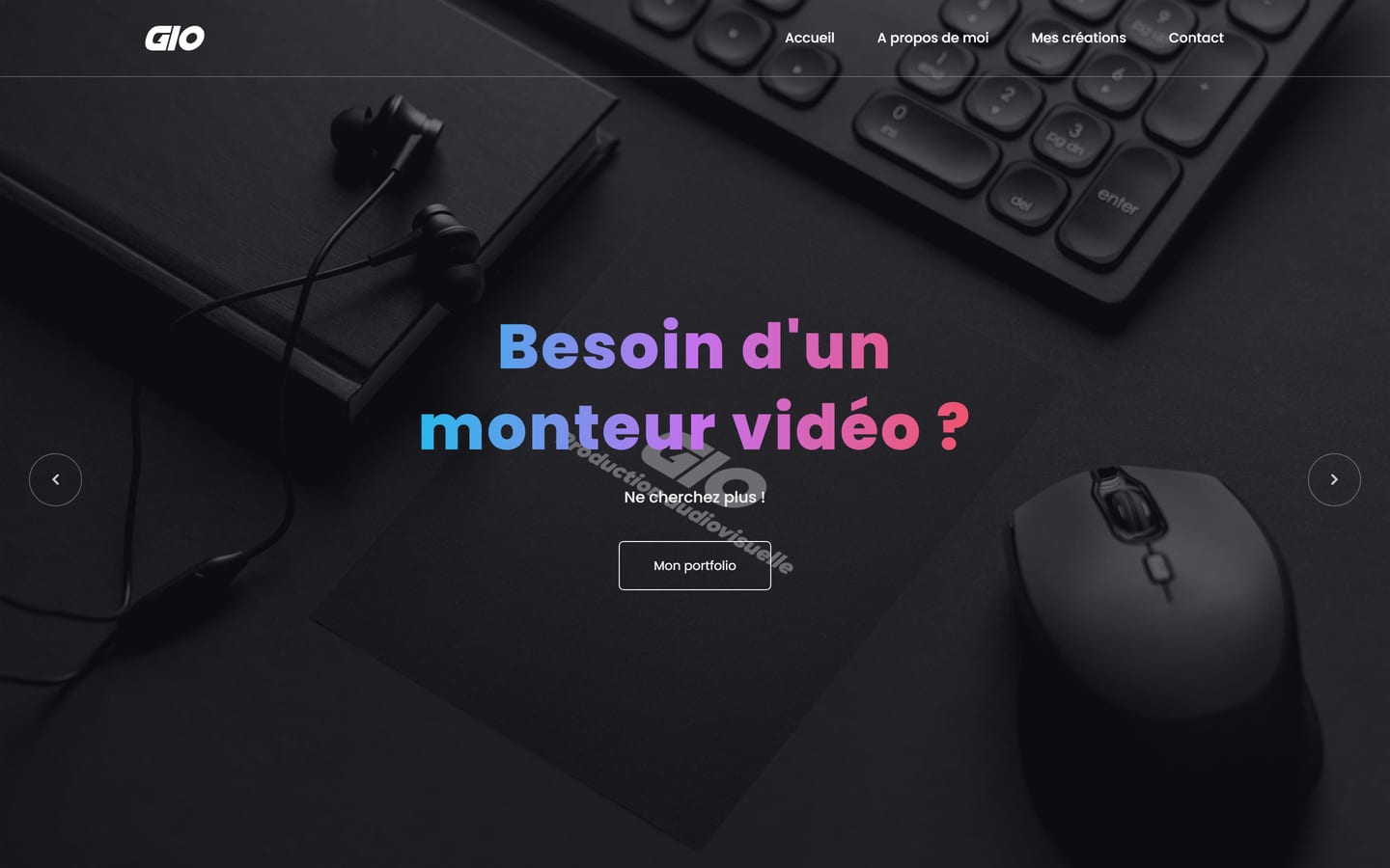 Accueil de Gio Prod sur ordinateur : « Besoin d'un monteur vidéo ? » en lettres dégradées sur une photo sombre de bureau, clavier et casque.